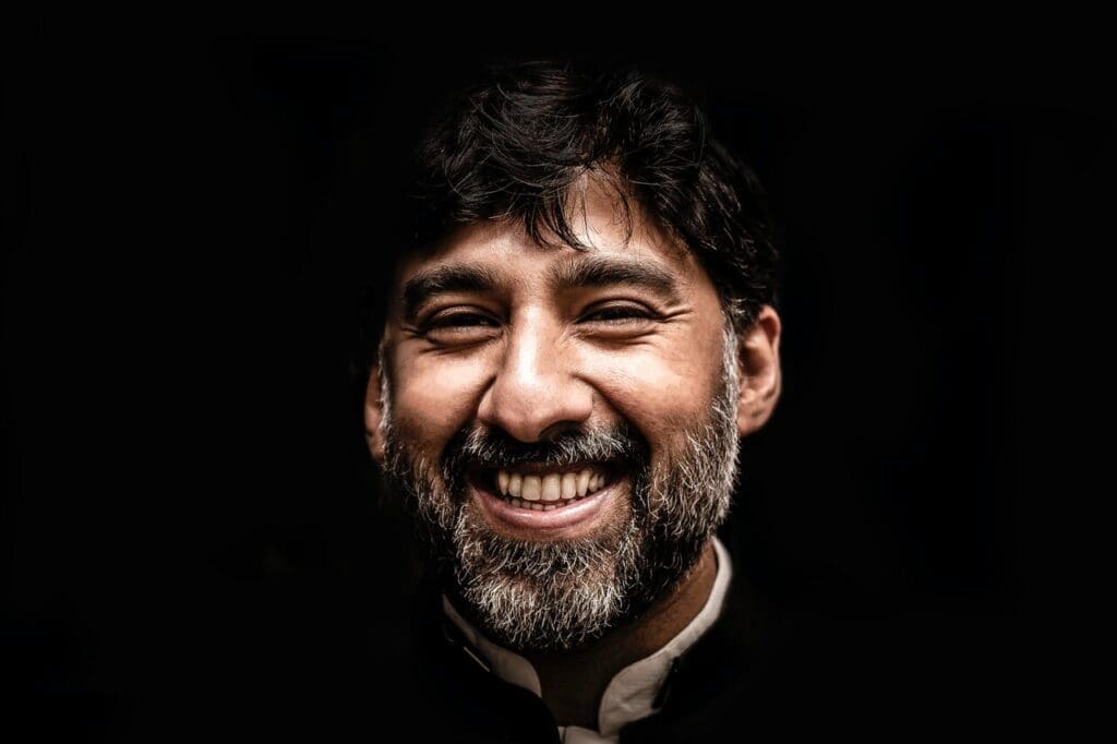 Man smiling against black background